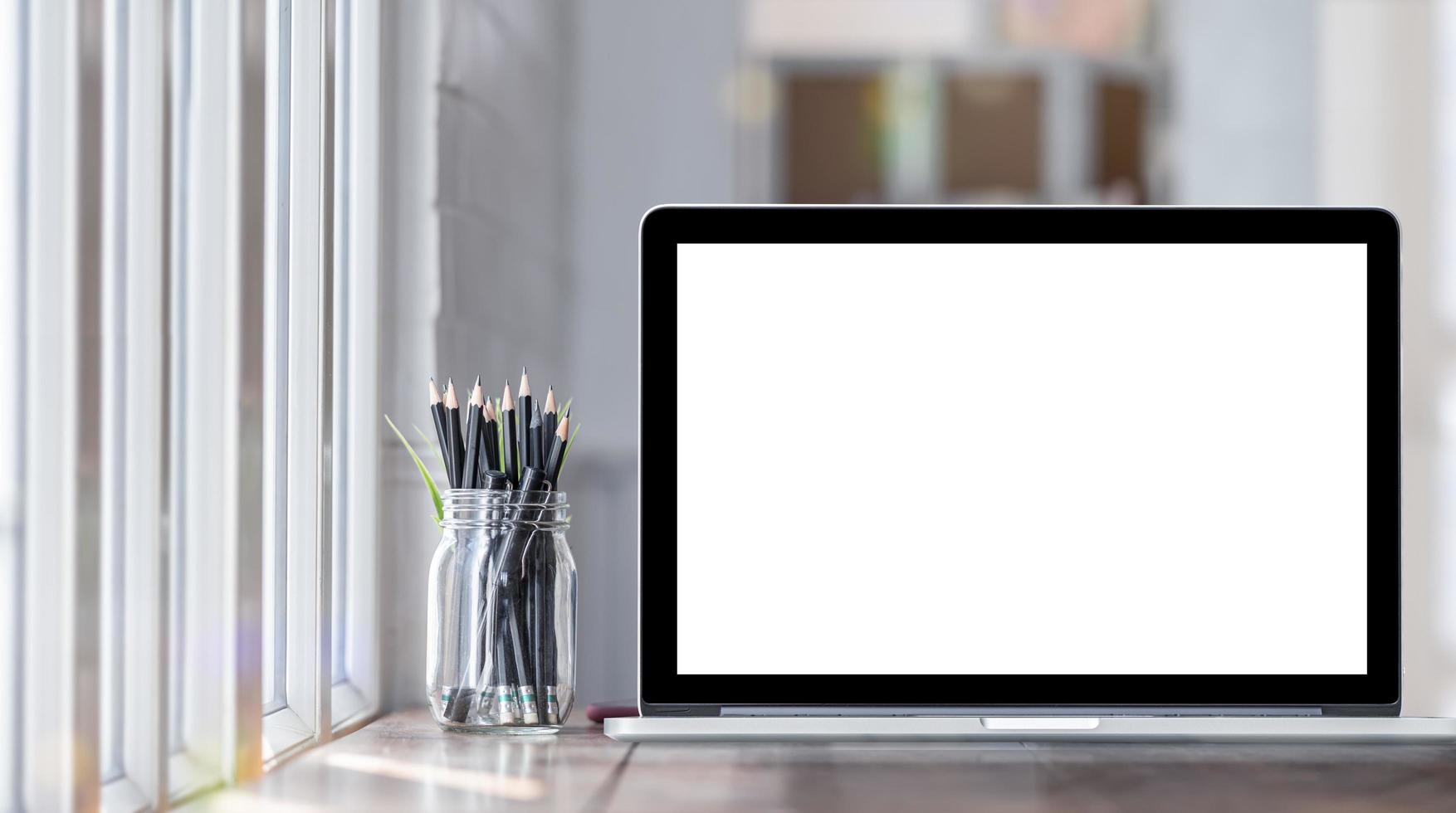 Laptop mockup with jar of pencils photo