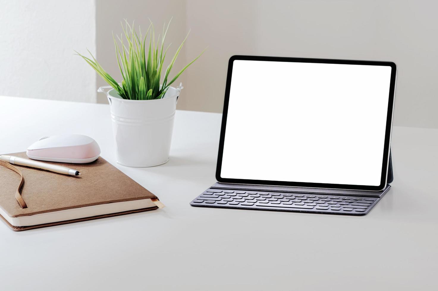 tableta con maqueta de teclado en mesa blanca foto