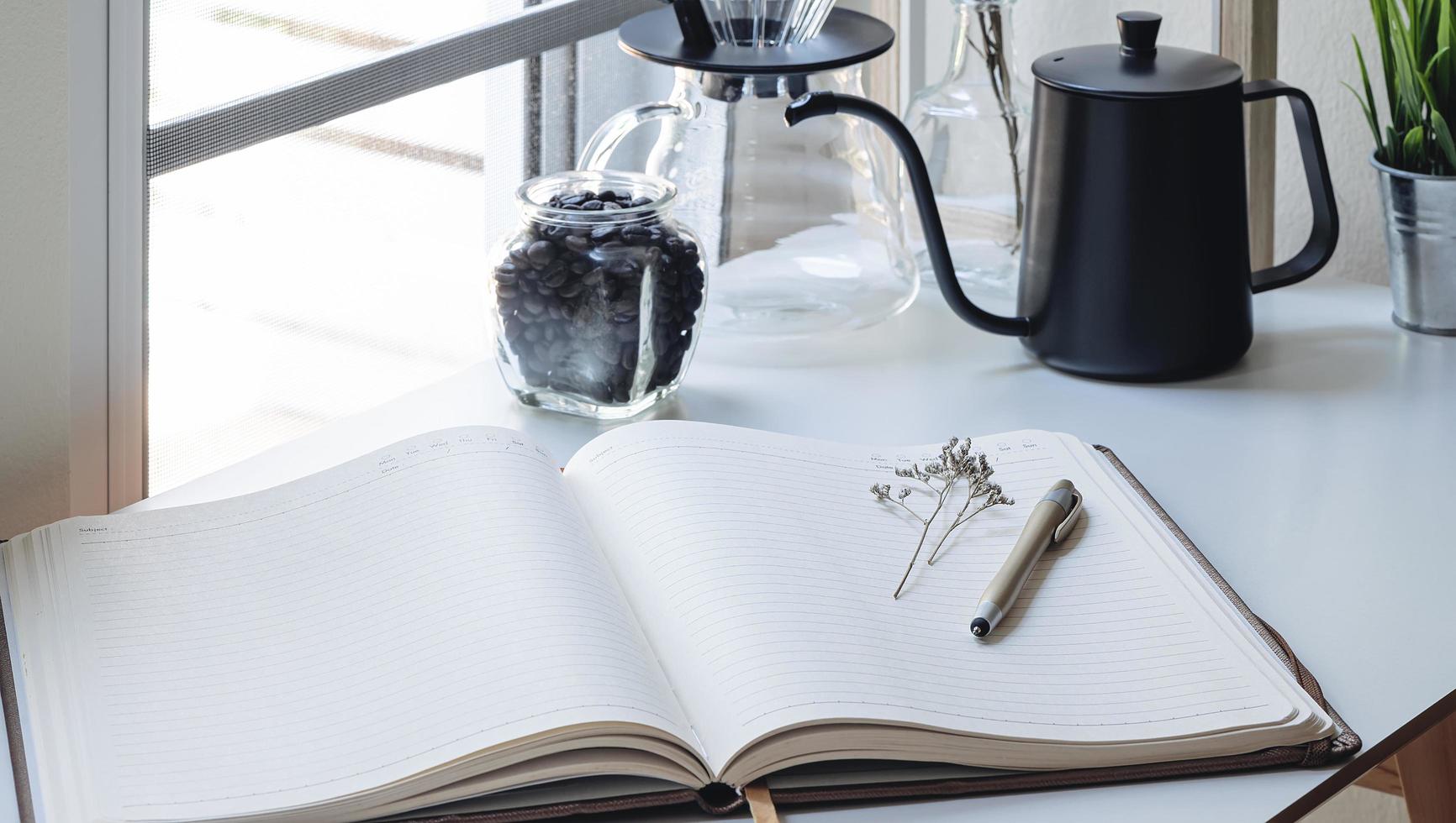 Open notebook next to a coffee maker photo