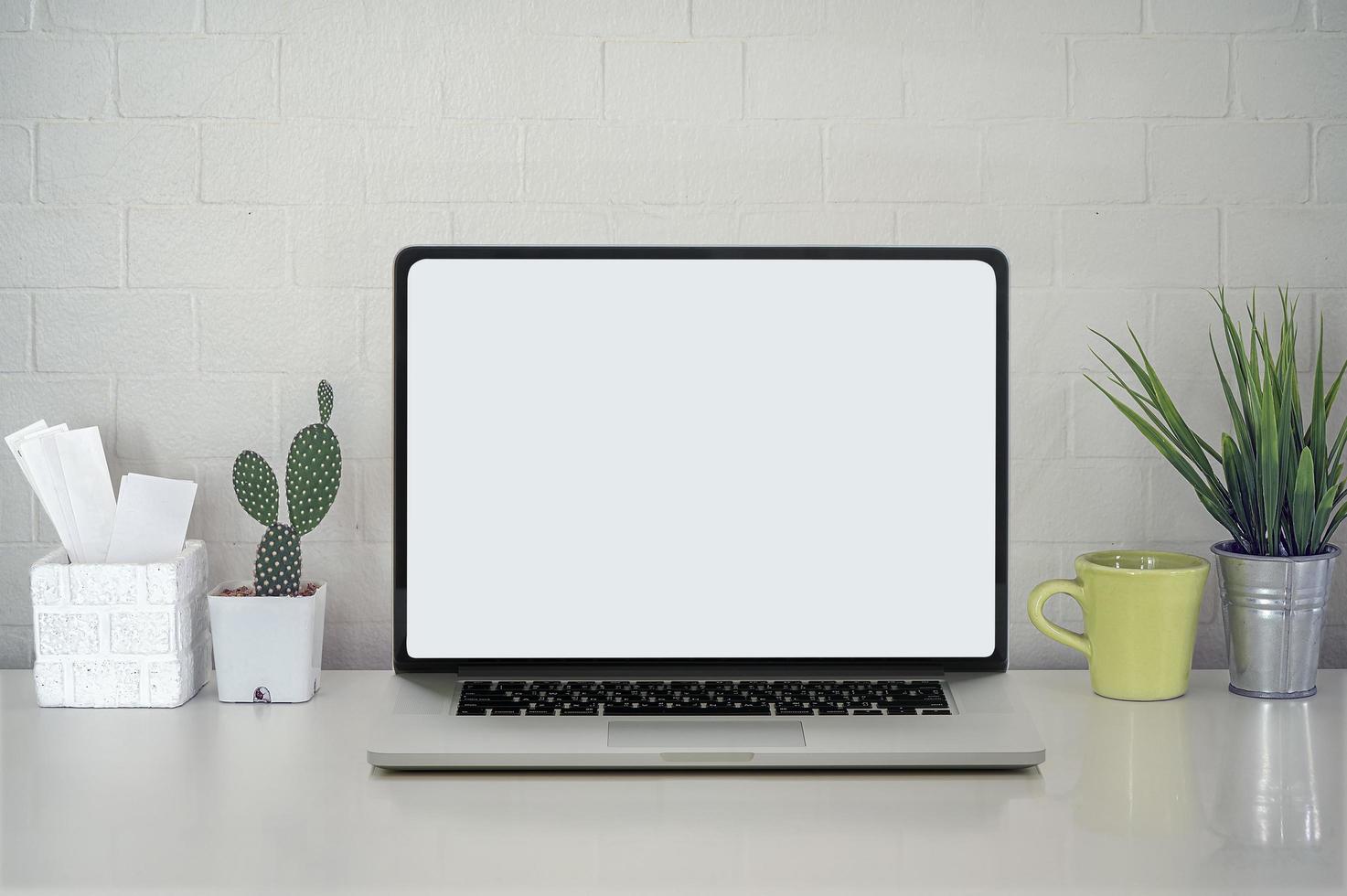 Laptop mockup with plants on a desk photo