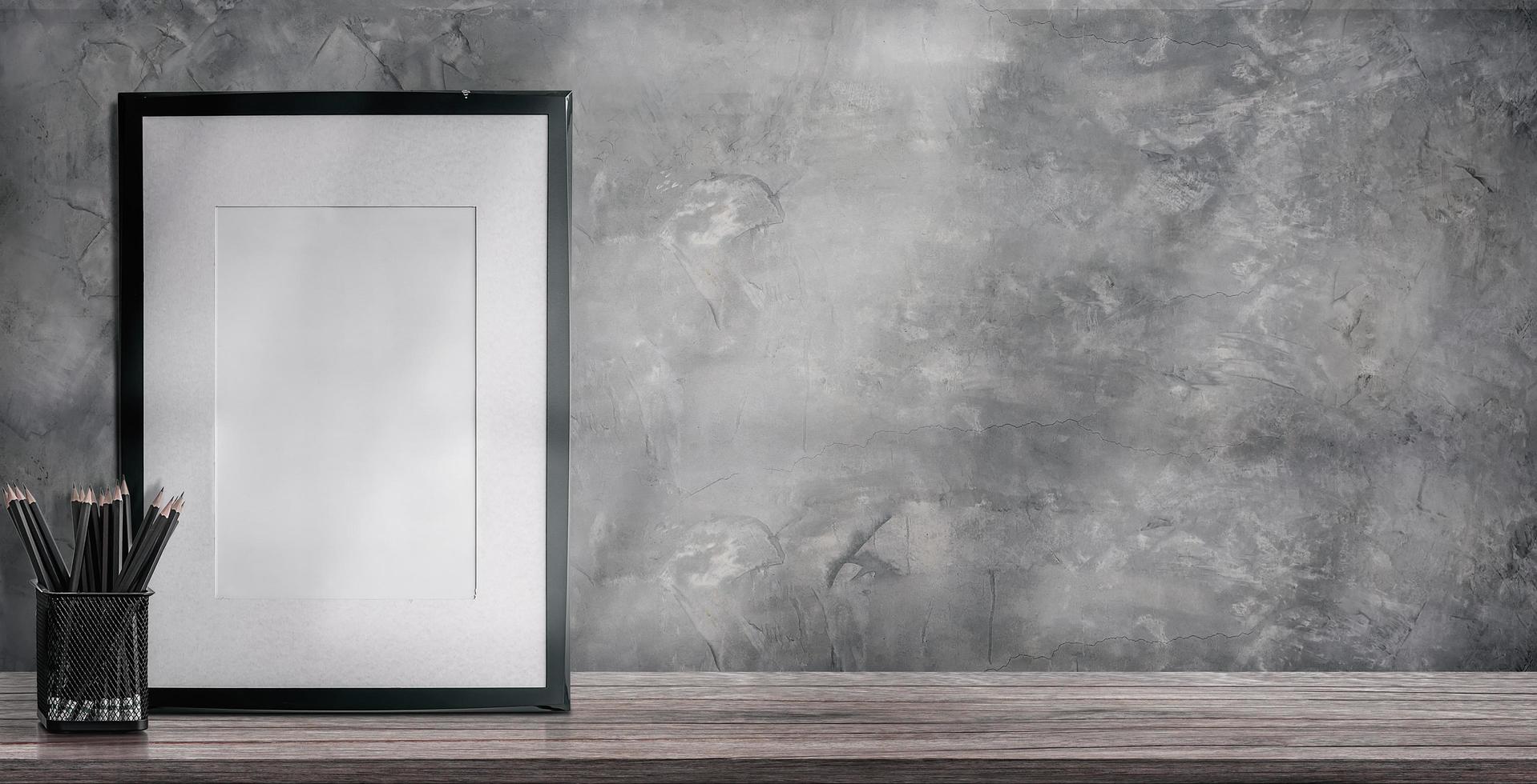 Mockup picture frame and pencils on a wooden table photo