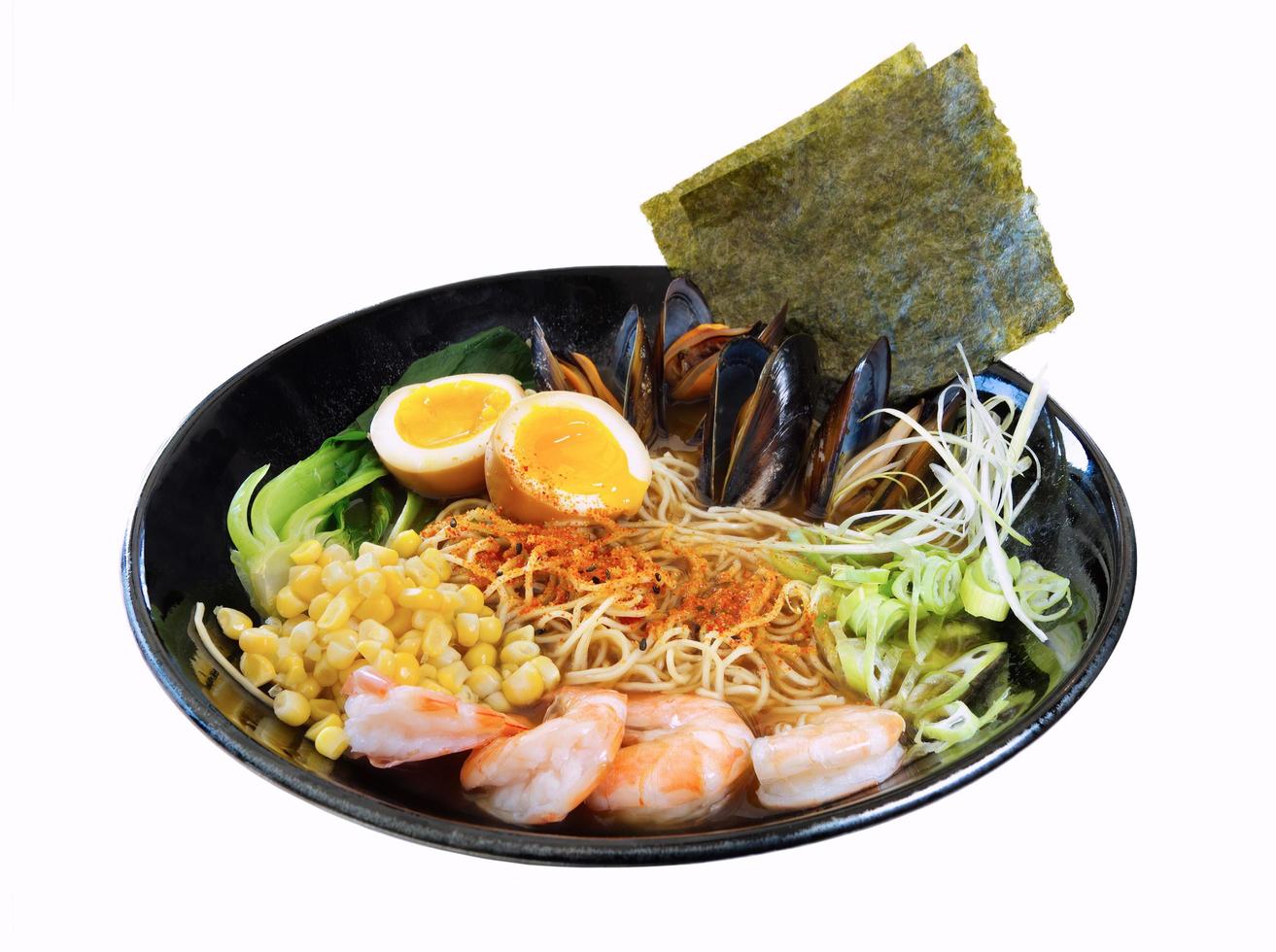 Un plato de ramen con mejillones y algas sobre un fondo blanco. foto