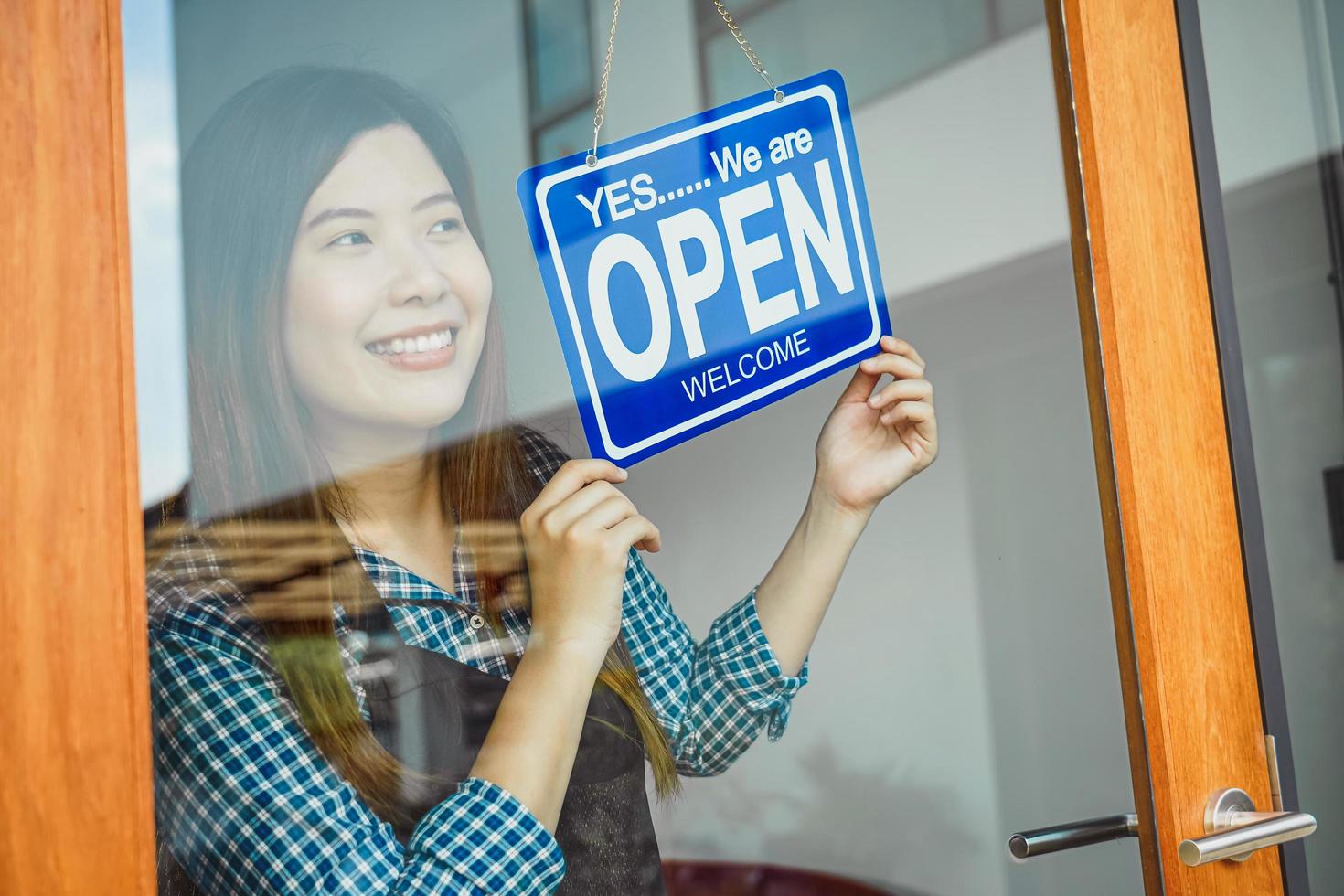 Woman flipping the open sign on a door photo