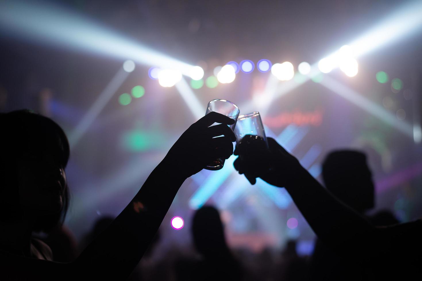 Silhouettes of people clinking glasses in a nightclub  photo