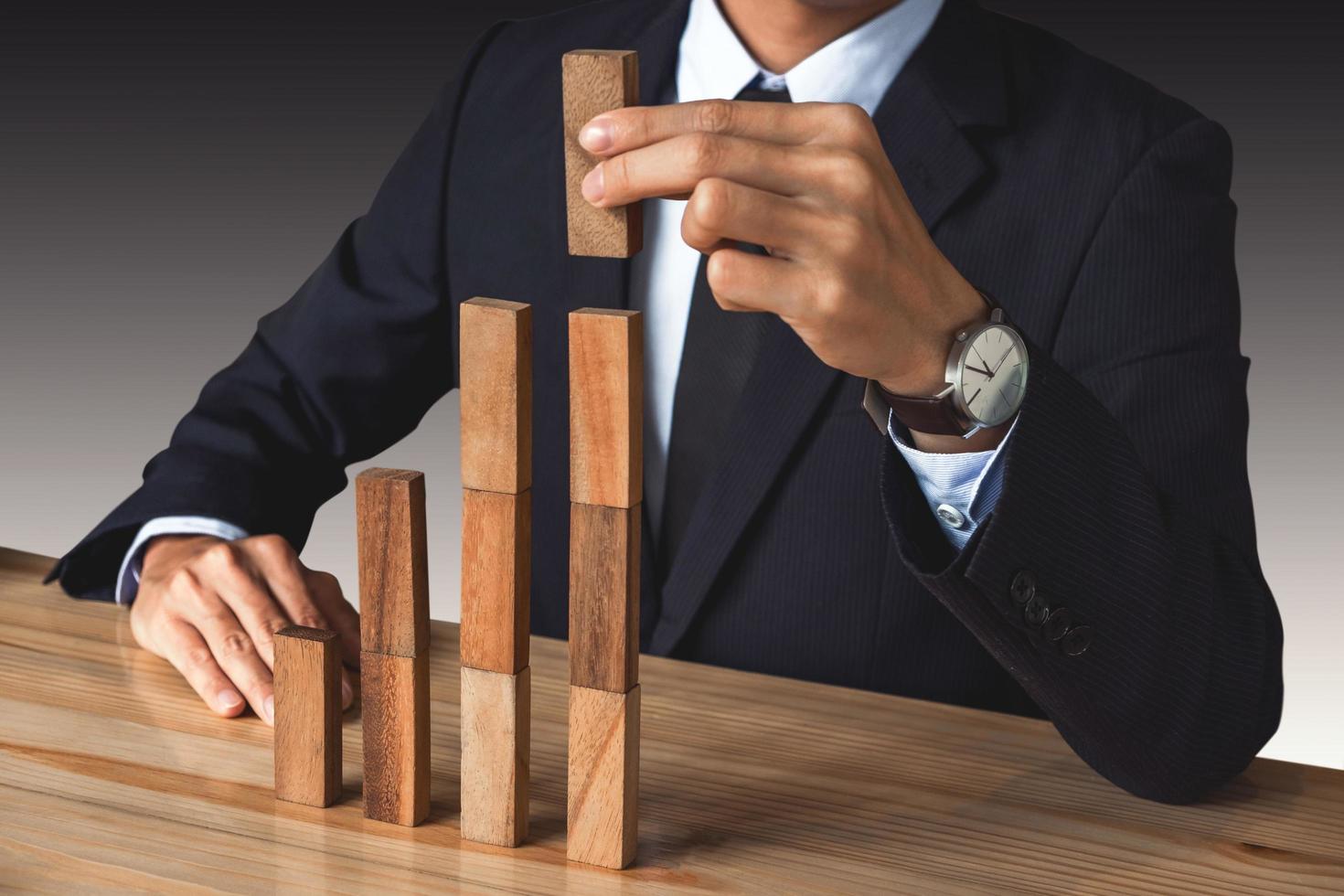 Businessman stacking wooden blocks photo