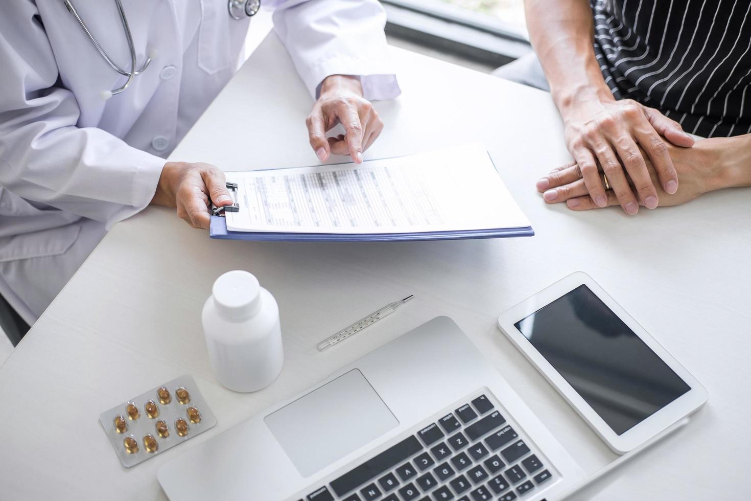 Close-up of a doctor reviewing medications with a patient photo