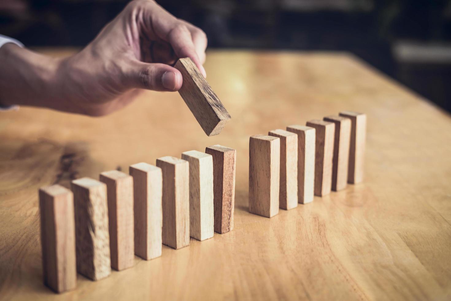 Close-up of a person lining up wooden blocks photo