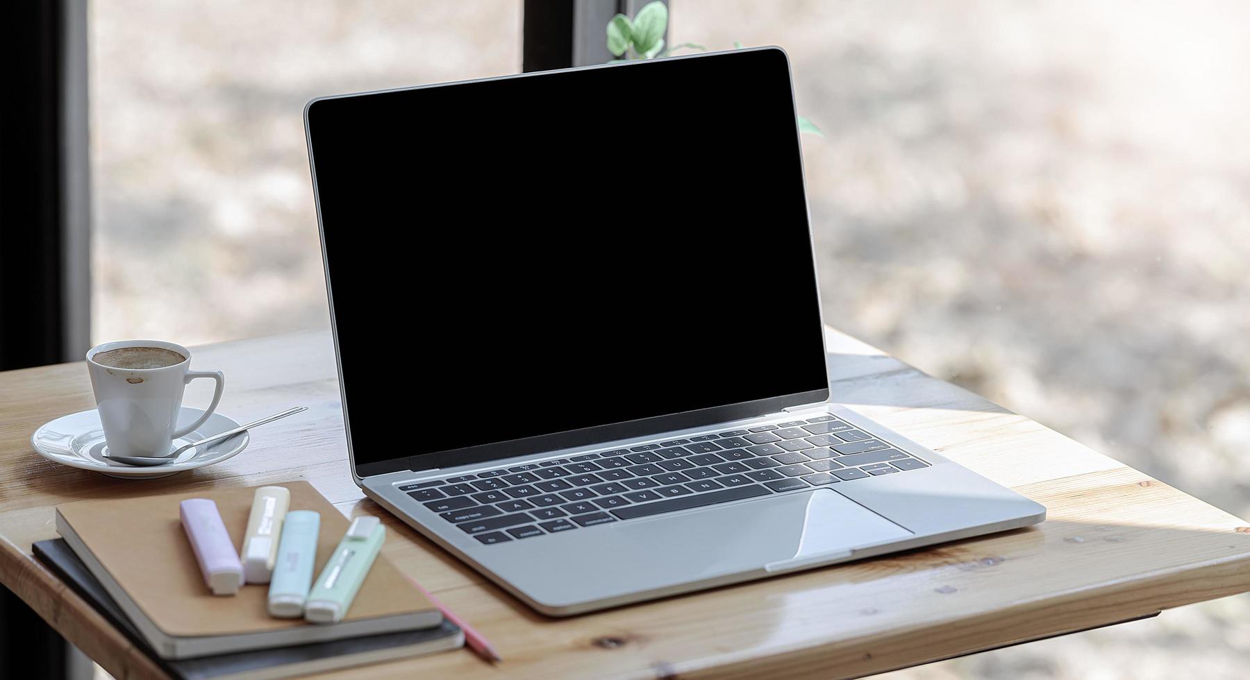 Laptop mockup on a desk near a window photo