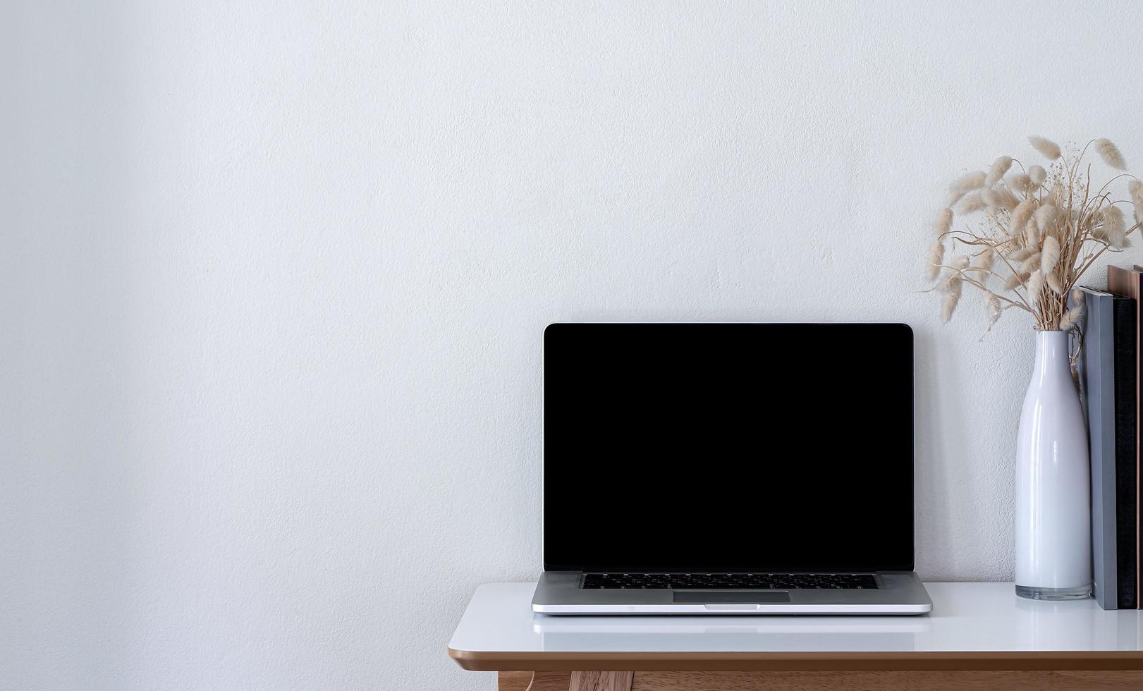 Laptop mockup with flowers on a table photo