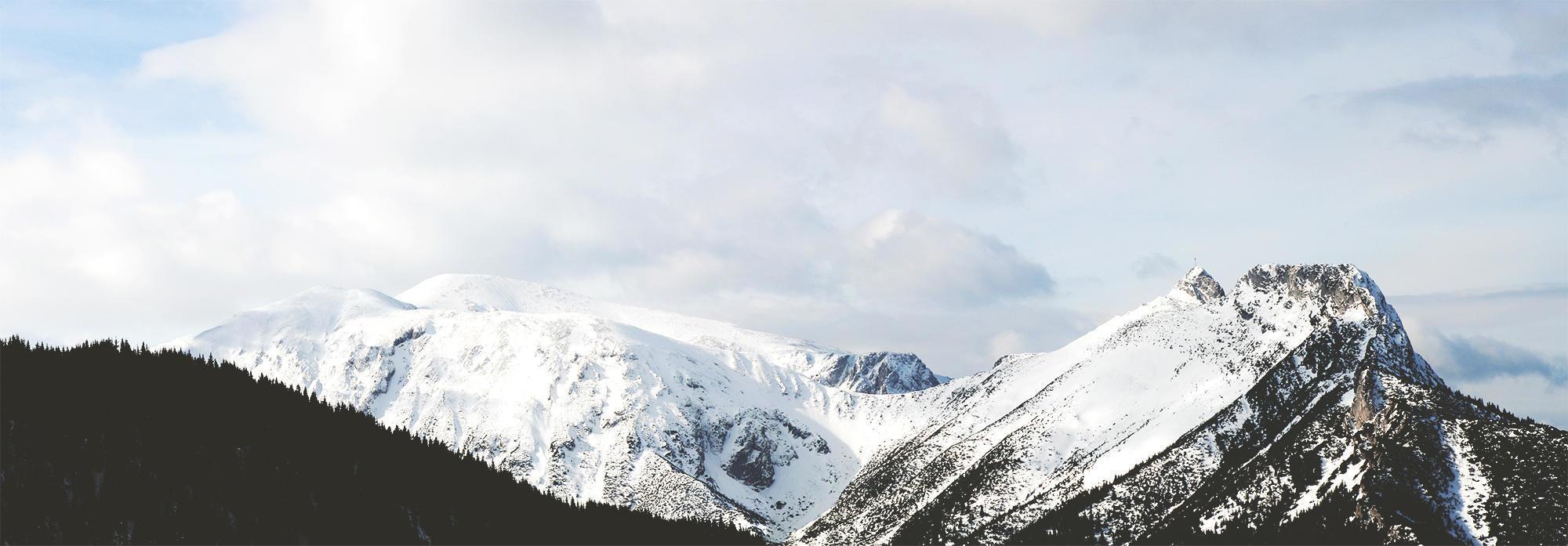 Vista panorámica de una montaña nevada bajo nubes blancas foto