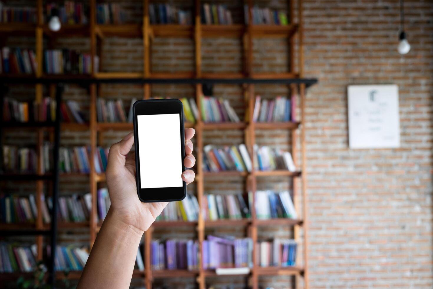 Smartphone mockup in front of a bookshelf photo