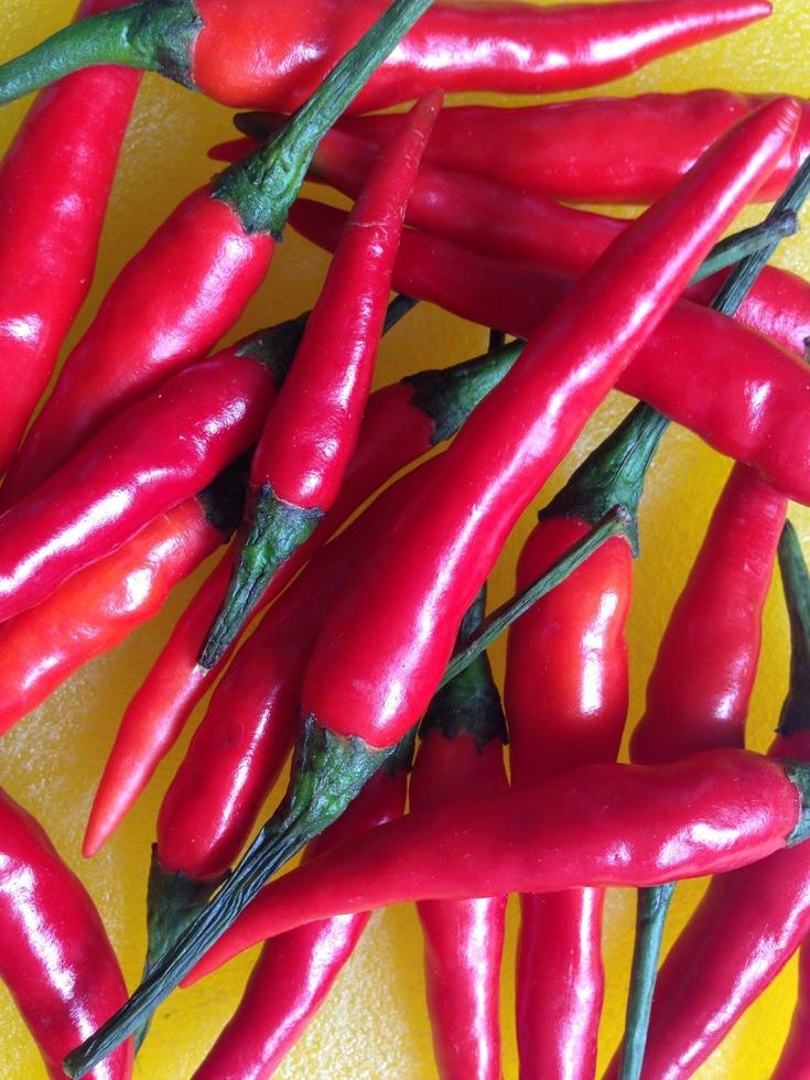 Red chilis on yellow background photo