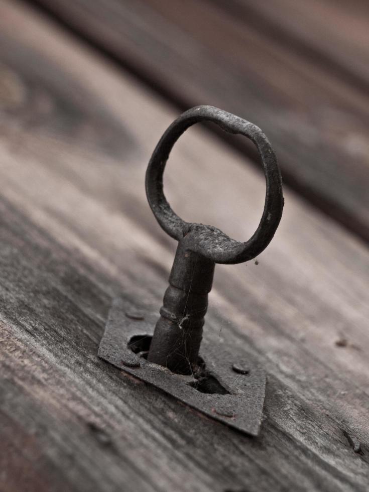 Metal key on a wooden door photo