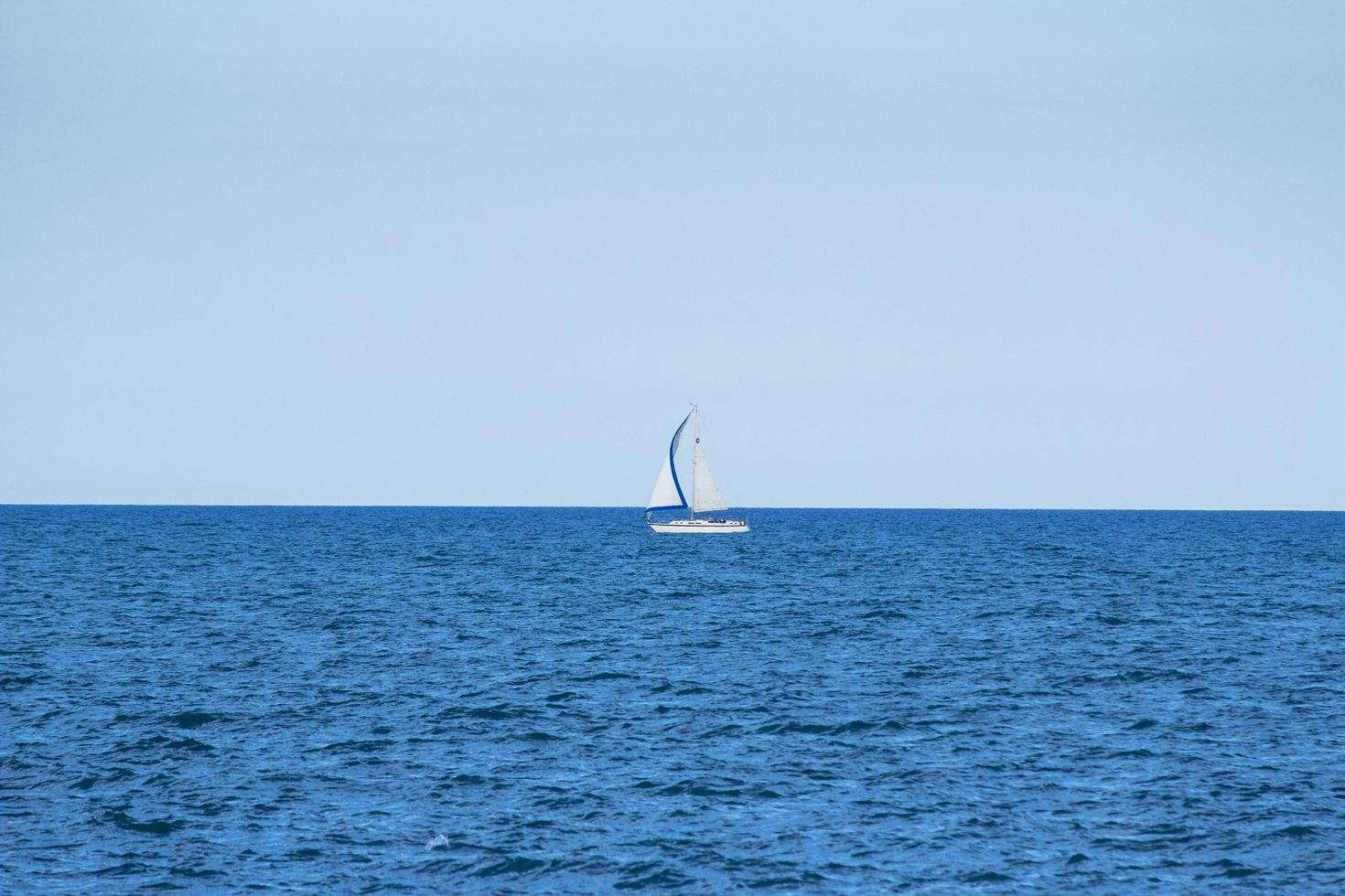 White sailboat in the ocean photo