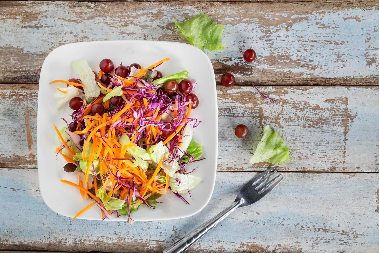 Ensalada de verduras en un recipiente sobre la mesa de madera foto