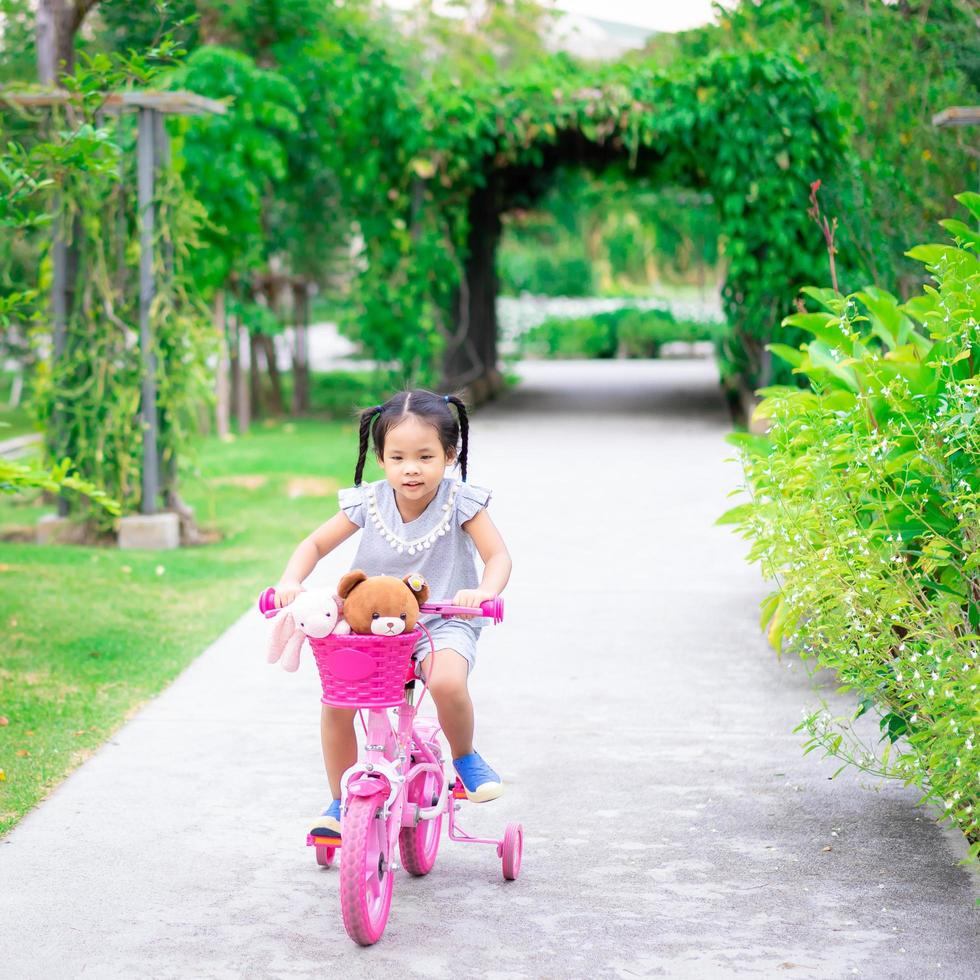 niña montando una bicicleta en un parque foto