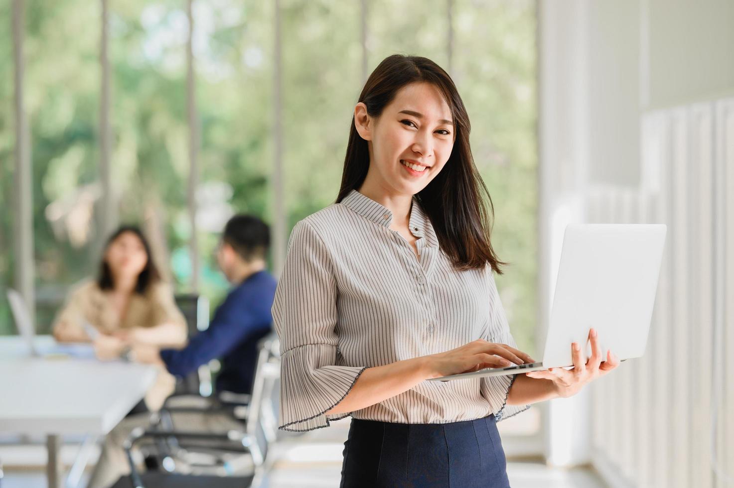 Asian woman holding a laptop photo