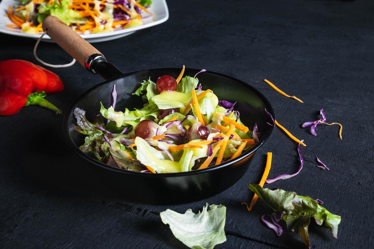 Vegetable salad in pan on black background photo