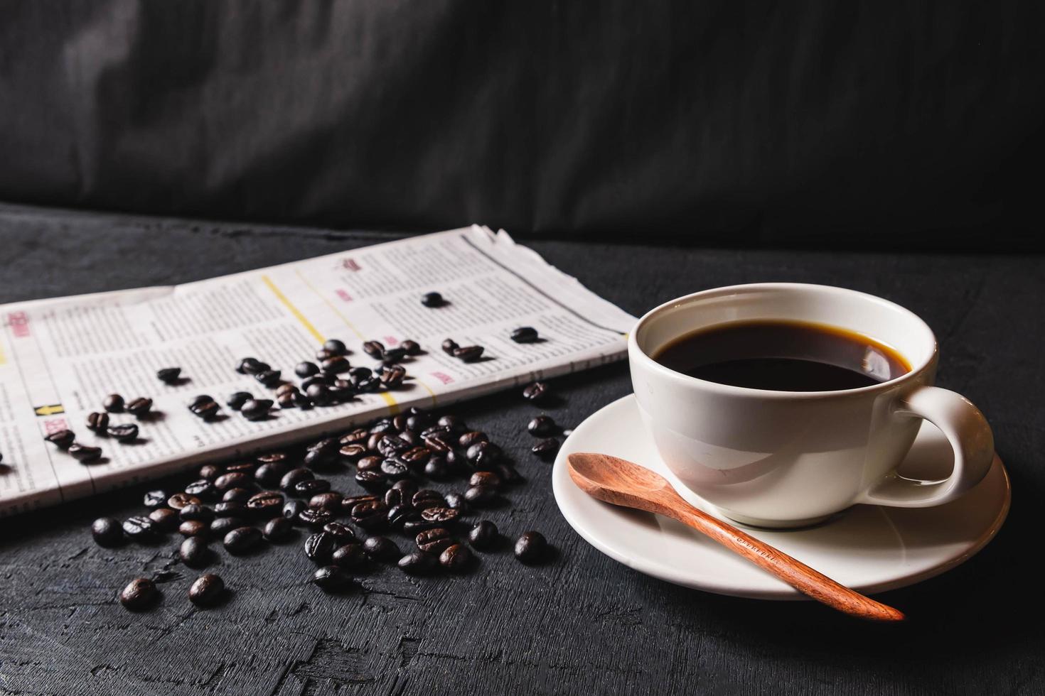 taza de café y granos de café en el periódico foto