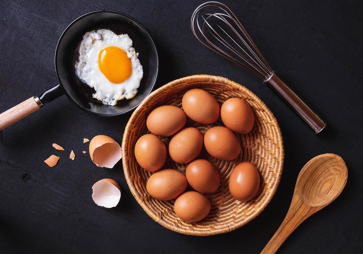 Frying pan with eggs and raw eggs  photo