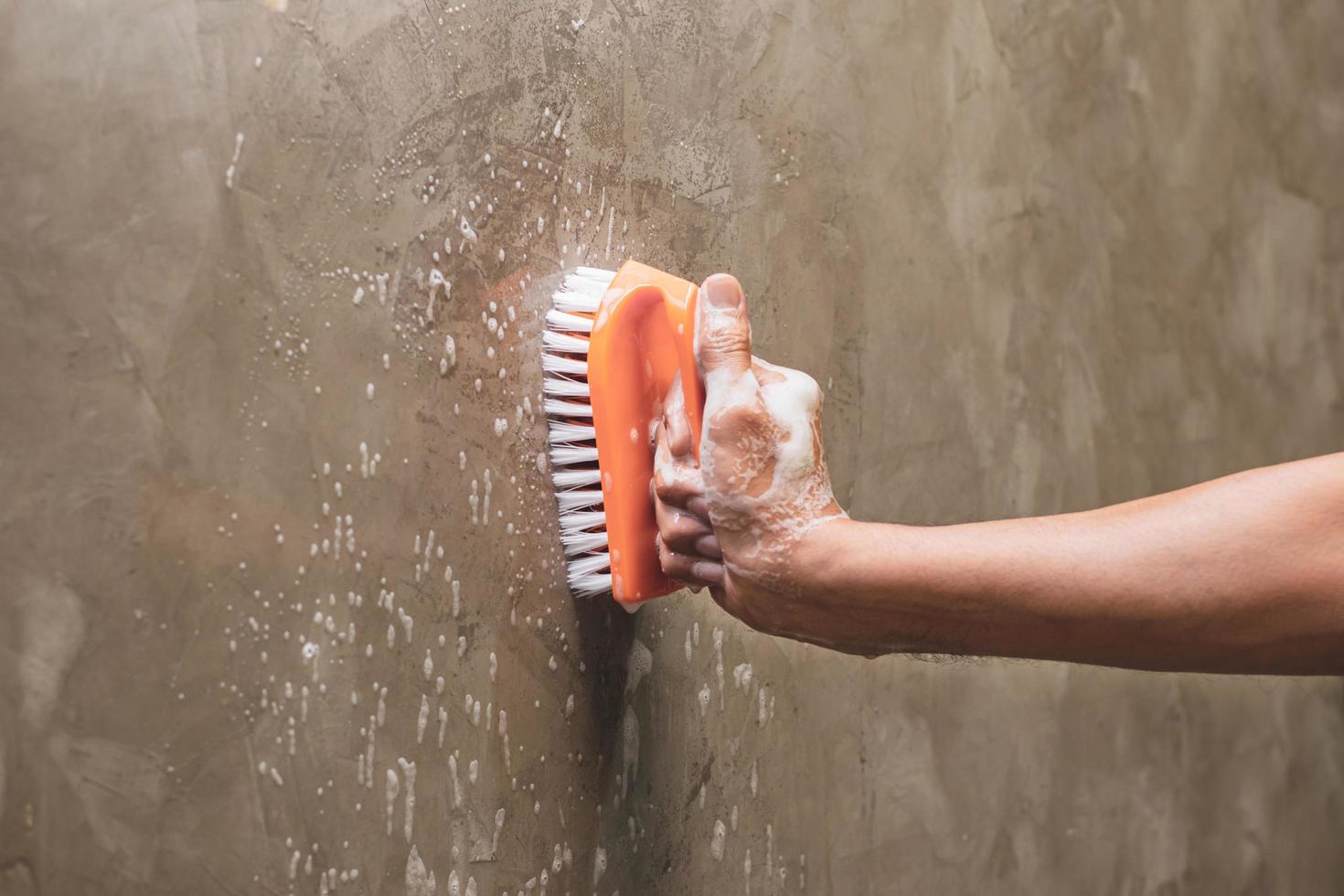 Close-up of a person scrubbing a wall photo
