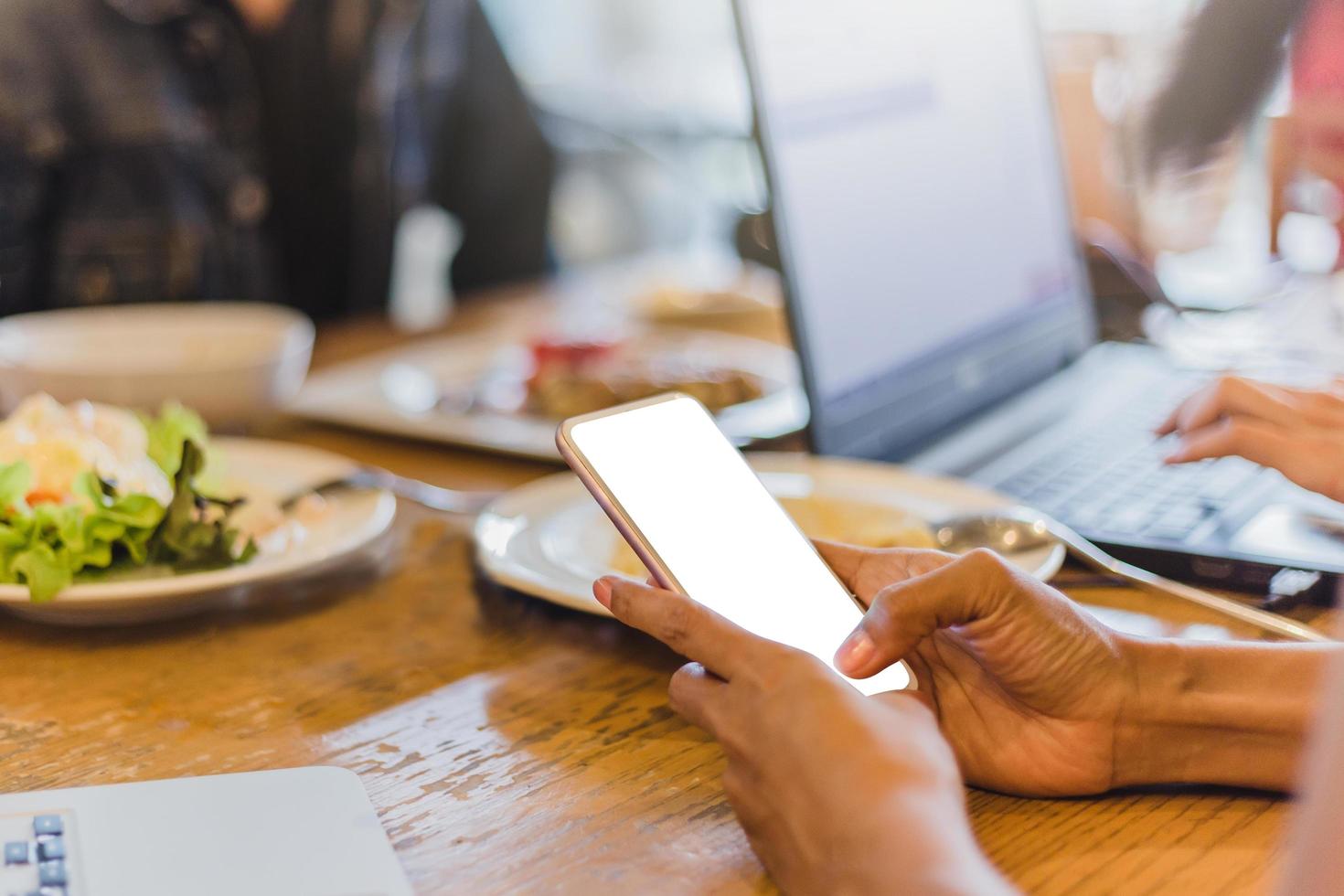 Mujer sosteniendo smartphone con pantalla en blanco en blanco foto