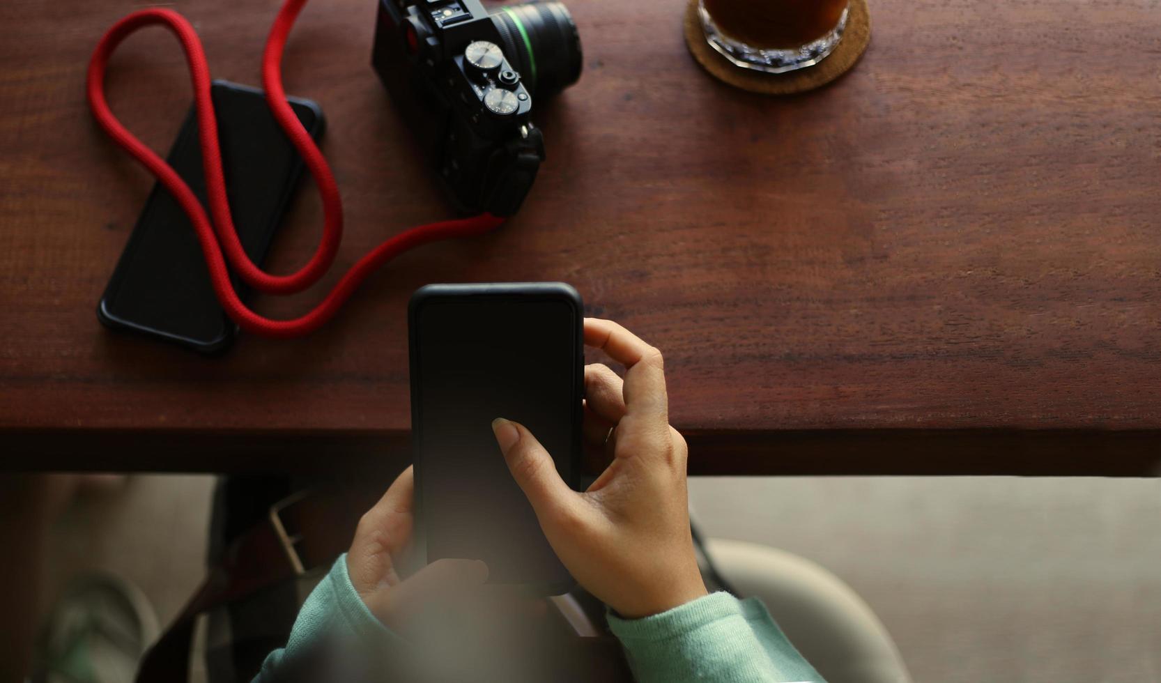 Girl uses mobile phone during coffee break in cafe photo