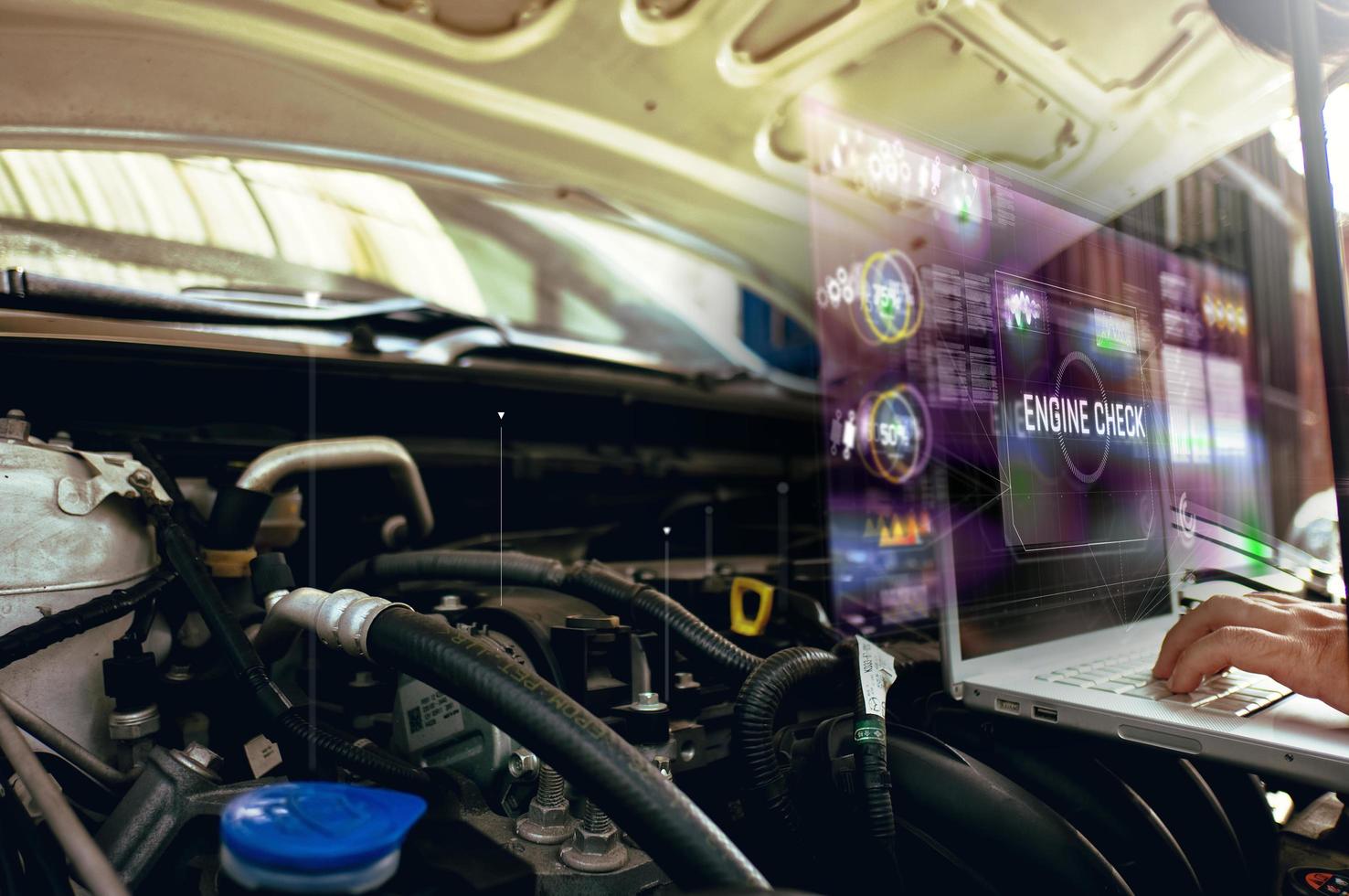 Technician uses laptop to analyze car engine with hologram photo