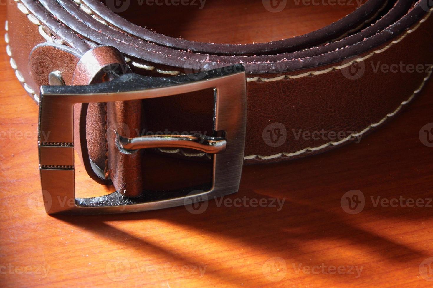 Leather belt on wooden background photo