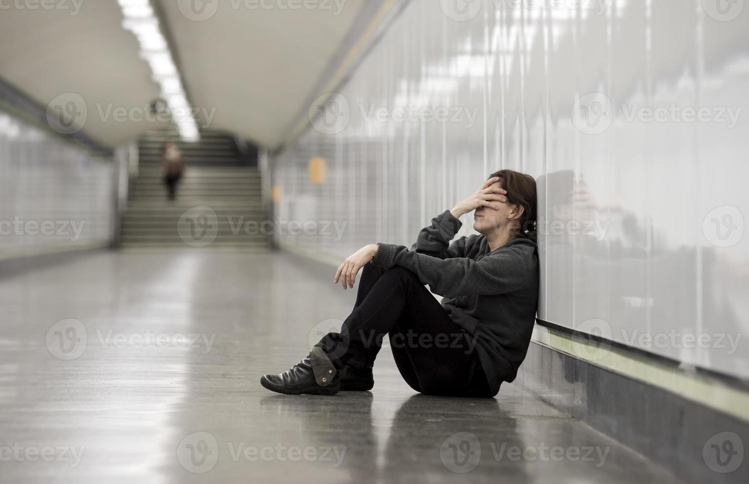 Joven mujer triste en el dolor solo deprimido en el túnel del metro foto