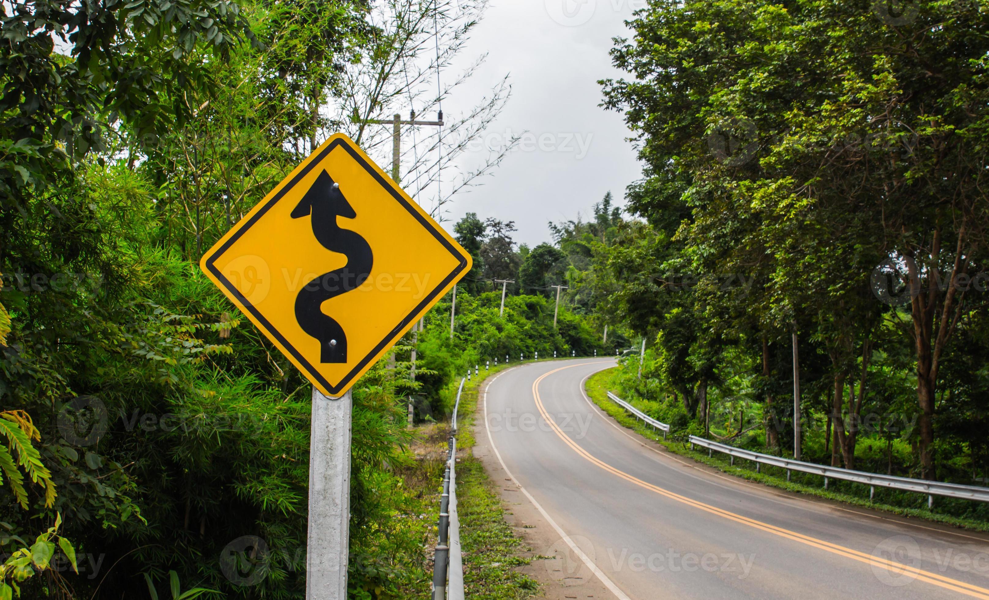 Curvy Road Sign To The Mountain In Rural Area Stock Photo