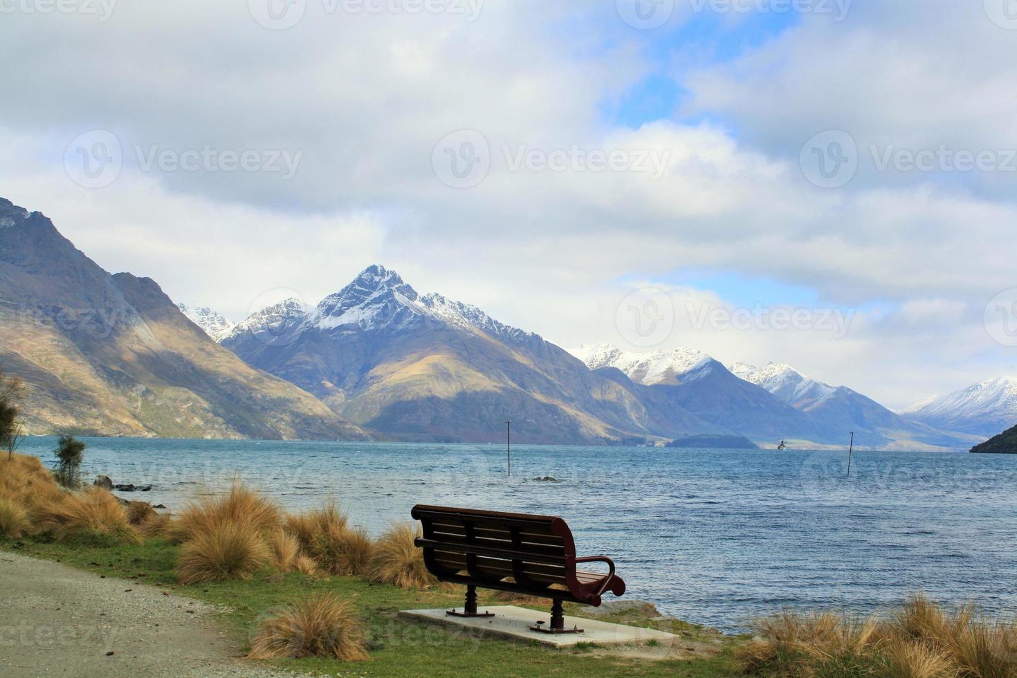 Lonely lake side seat on a winters day photo