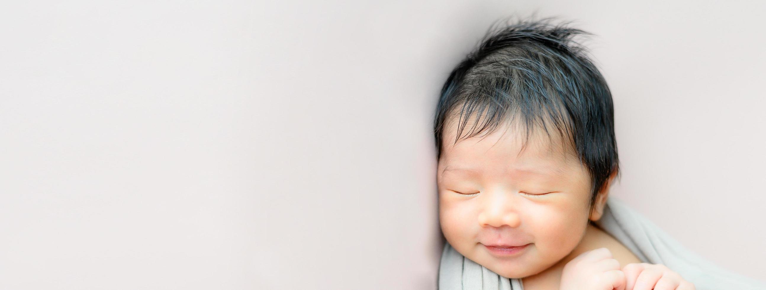 bebé recién nacido asiático durmiendo foto