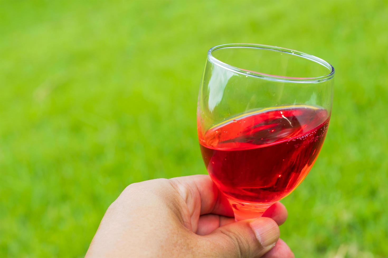 Close up hand holding red wine photo