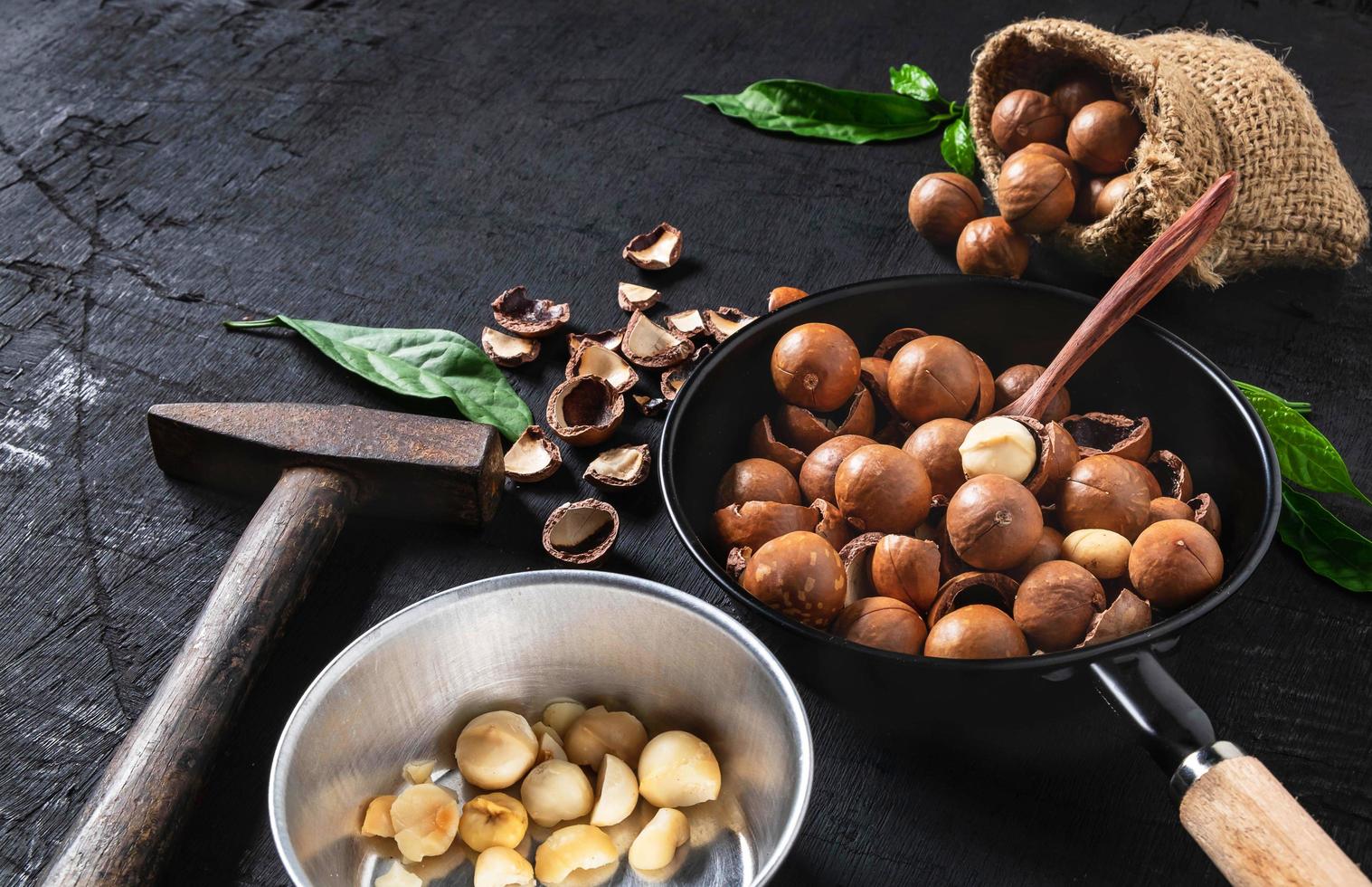 Nueces de macadamia sobre un fondo de madera negra foto