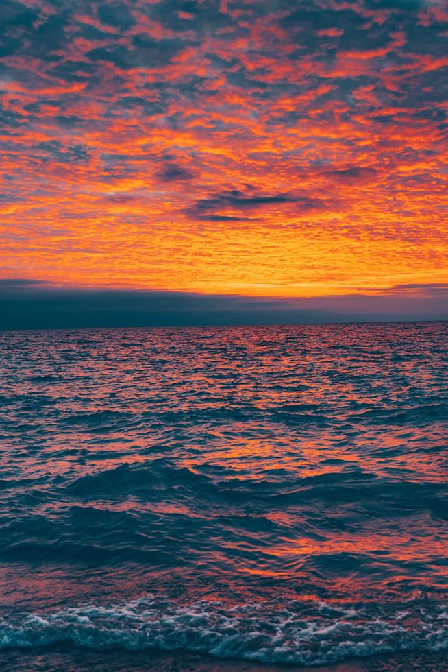 Bright sunset over rippling ocean photo