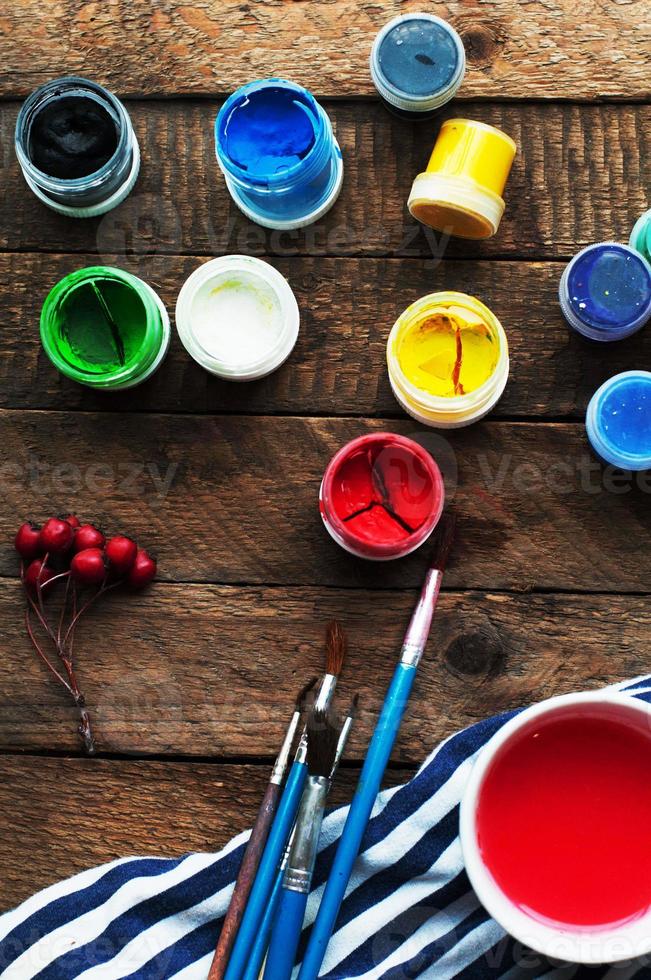 Art of Painting. Paint buckets on wood background. photo