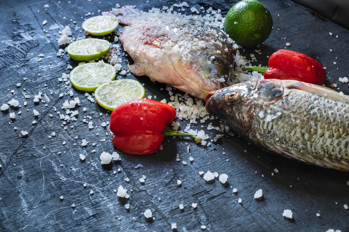 pescados de tilapia fresca con sal y condimentos foto