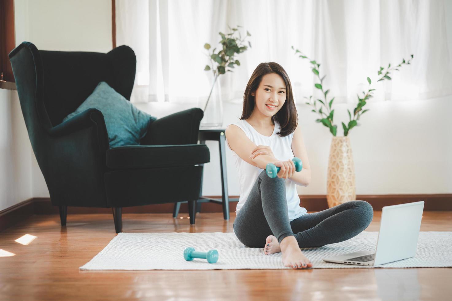 Mujer asiática con mancuernas en casa foto