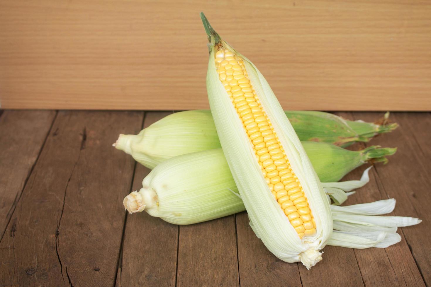 Close up fresh corns on wooden background photo