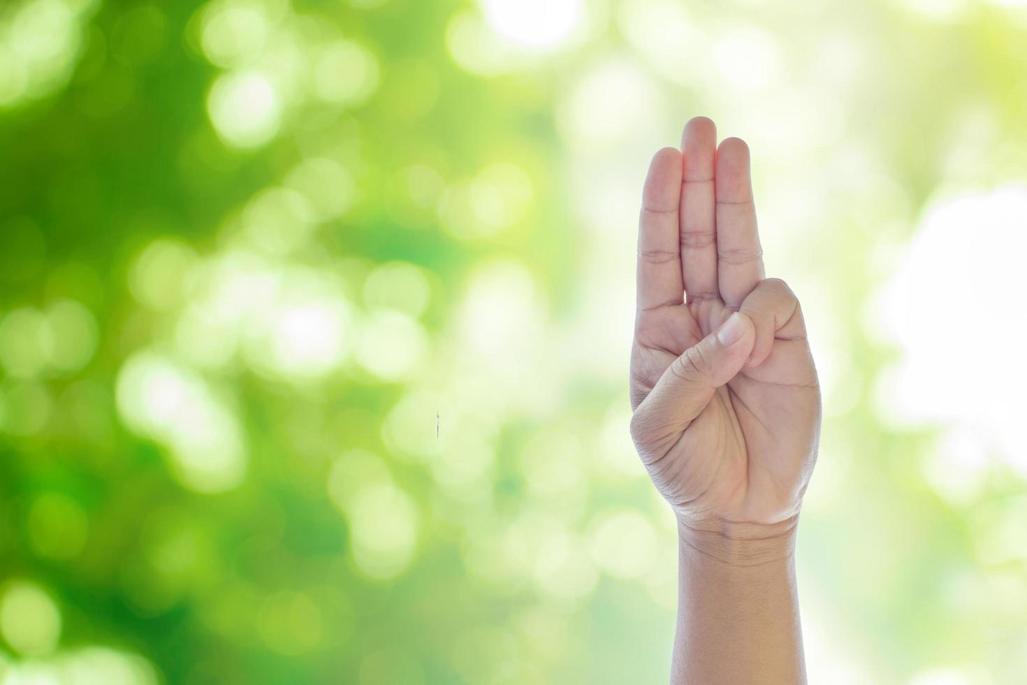 Hand on green natural bokeh background photo