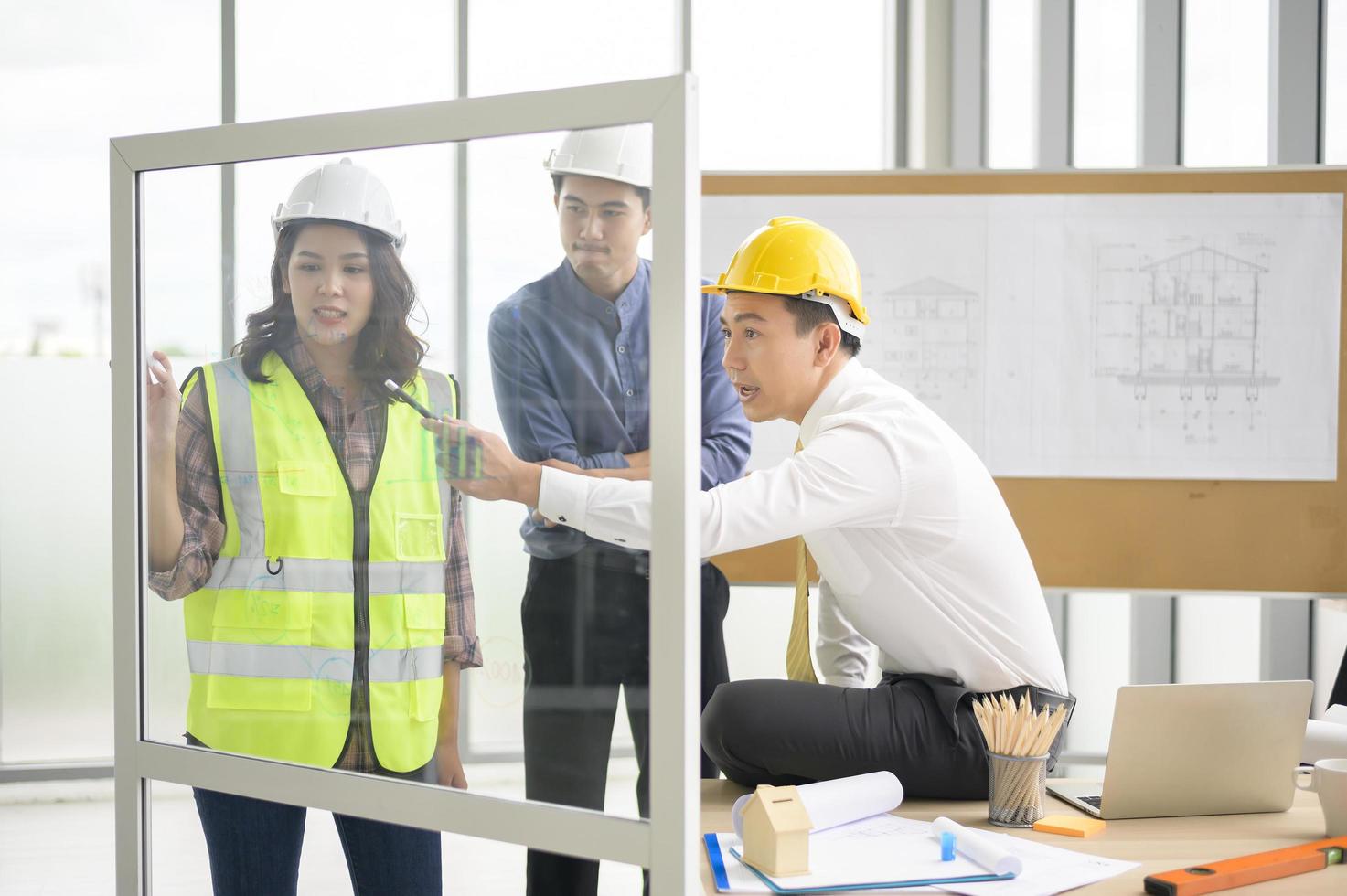 People in hard hats discussing blueprint plans photo