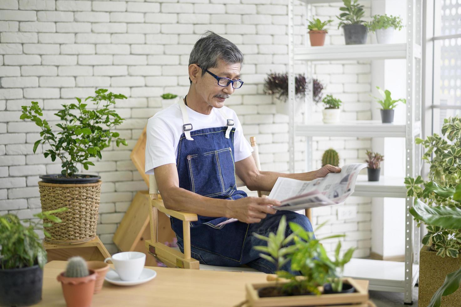 An elderly man is reading the newspaper  photo