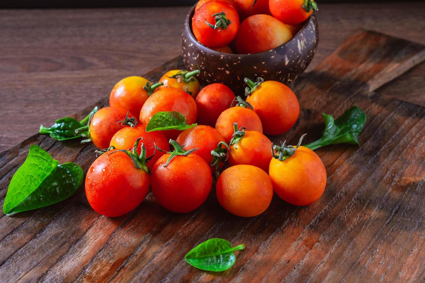 Tomates rojos frescos sobre fondo de madera foto