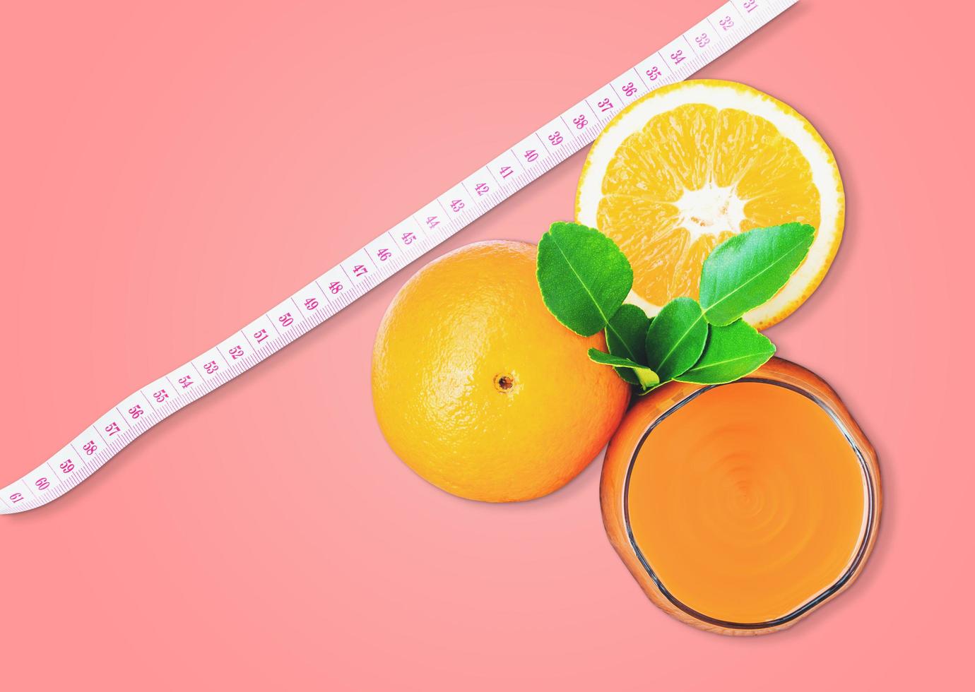 Top view of orange juice and oranges with measuring tape photo