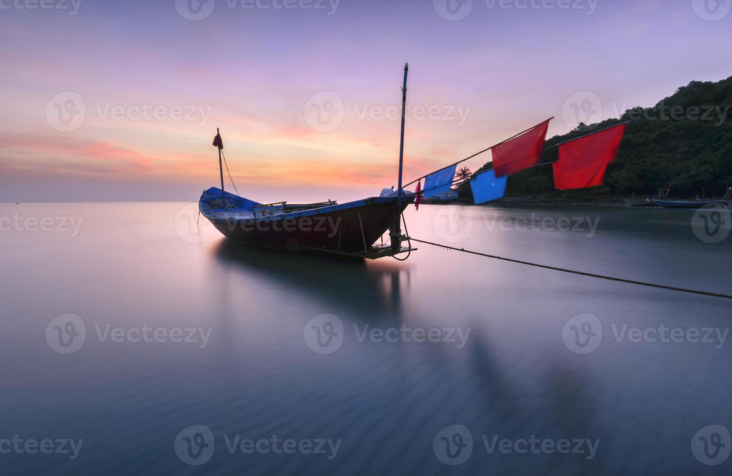 Barcos de pesca en la playa durante la puesta de sol foto