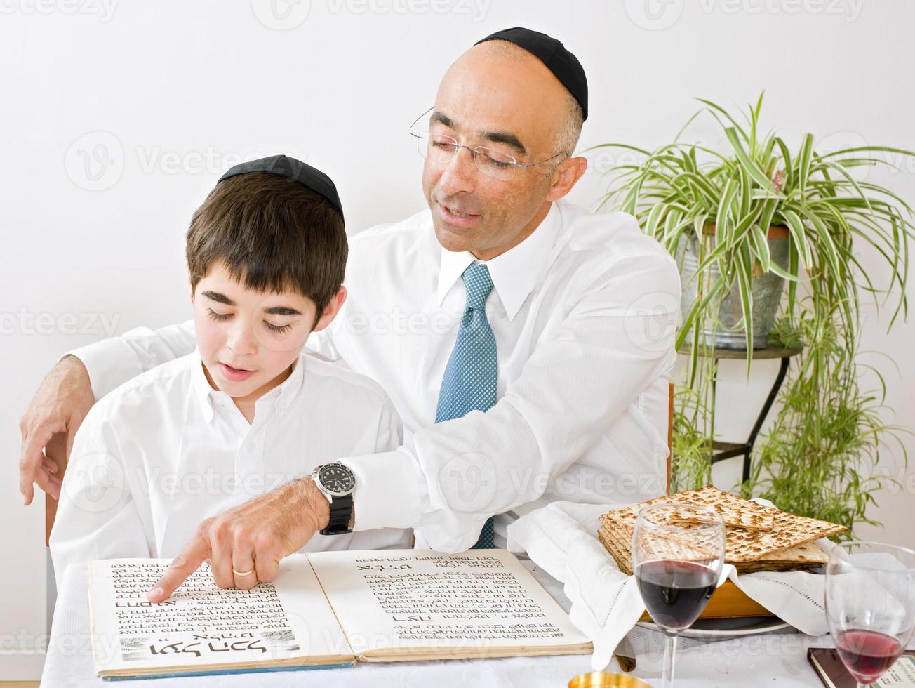 A father and son celebrating Passover and reading photo
