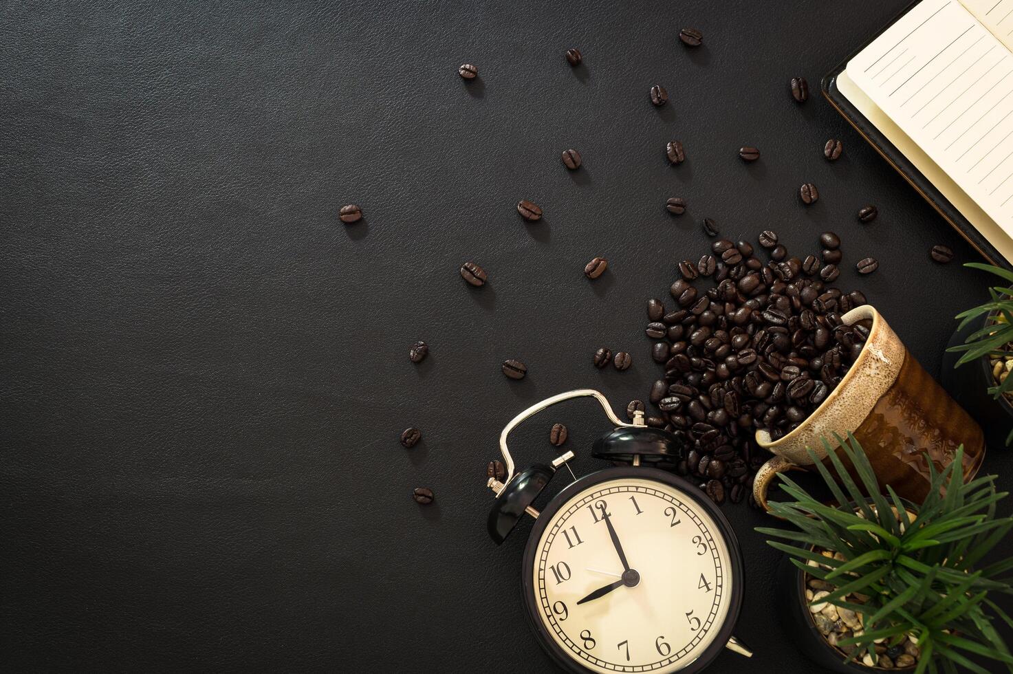 granos de café, reloj y un cuaderno foto