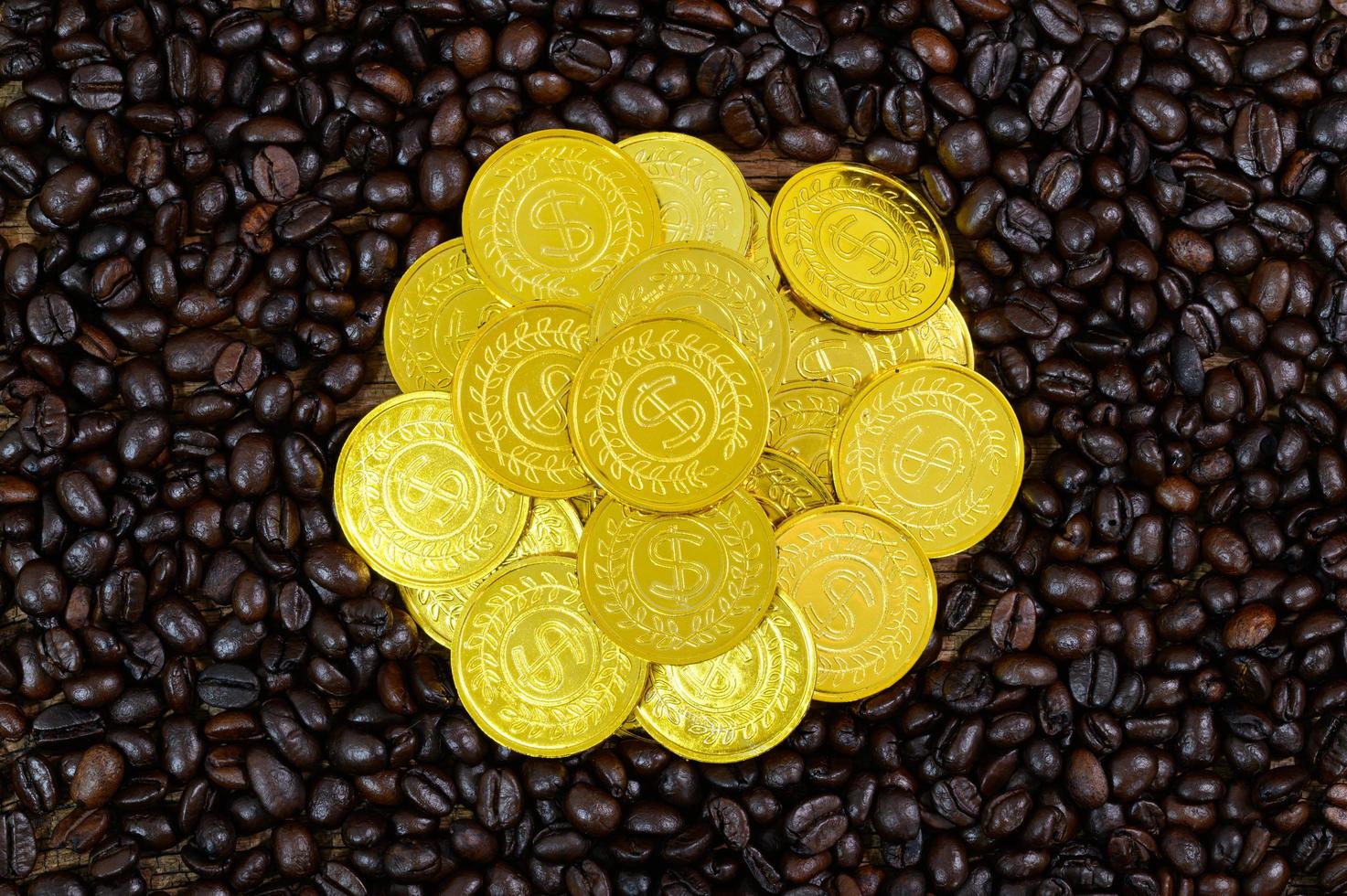 monedas de oro colocadas en granos de café foto