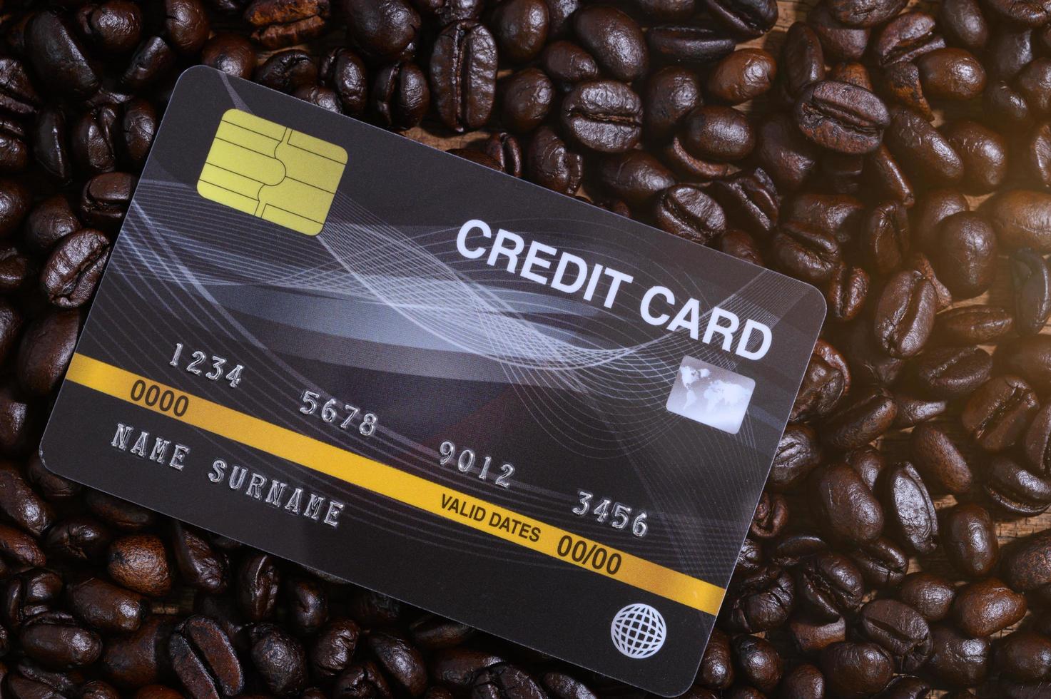 tarjeta de crédito colocada en granos de café foto